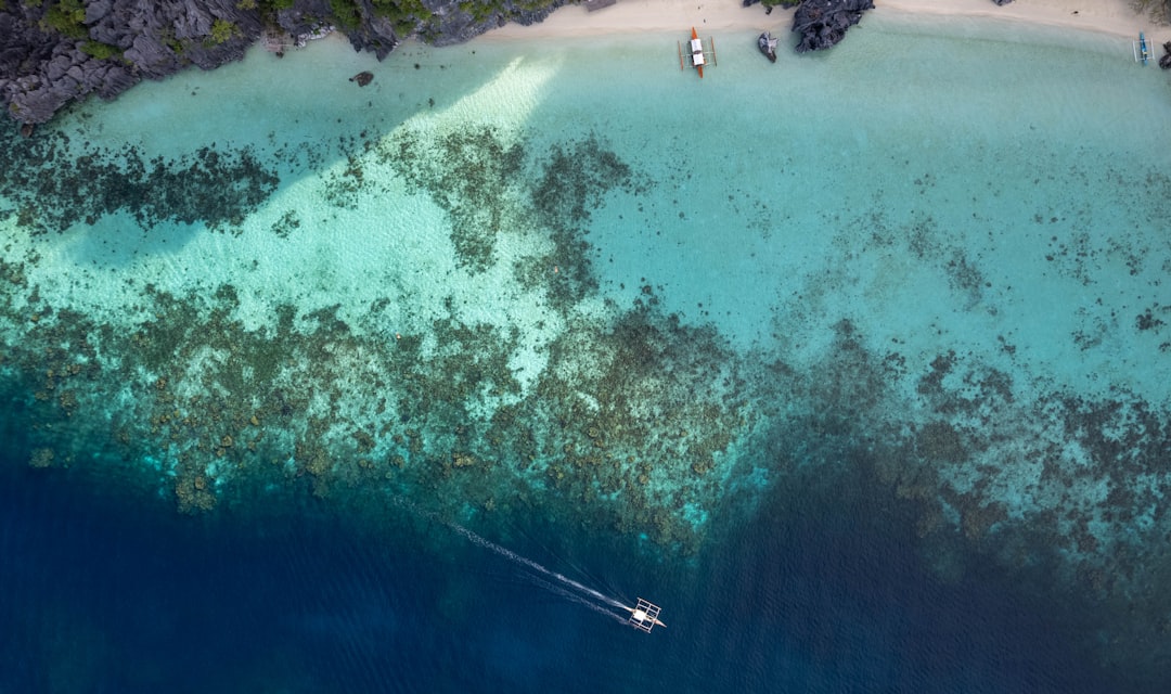 Boat sailing on crystal clear tropical ocean water